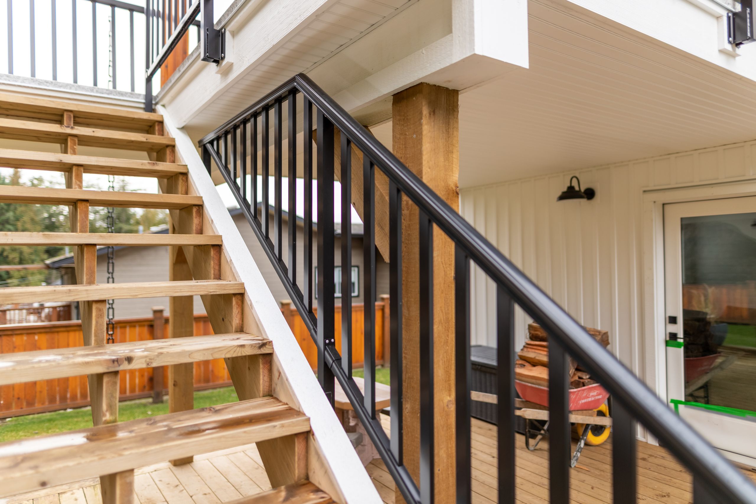 Glass deck stair railing installation showing tempered glass panels on aluminum frame following the stair pitch on residential property