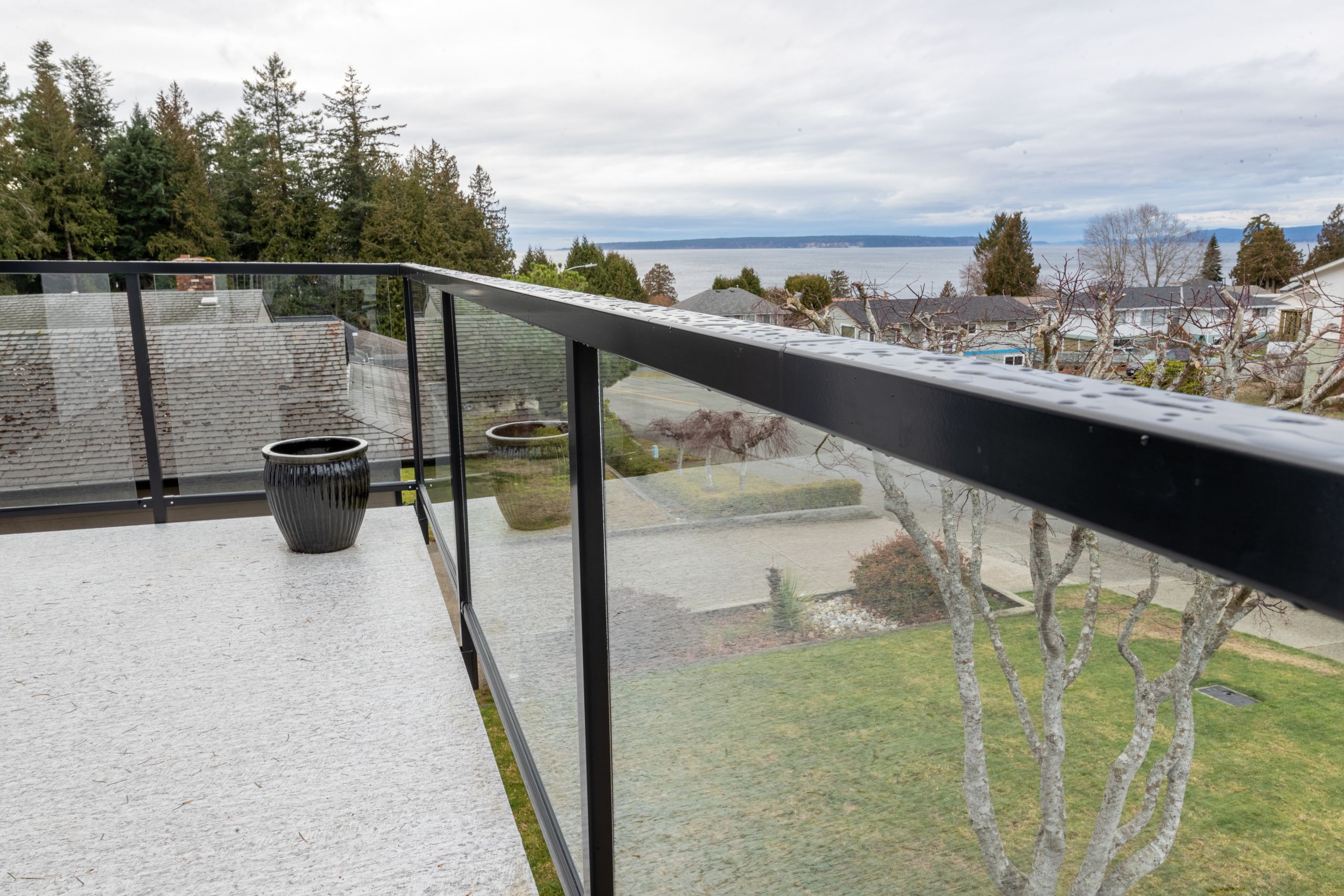Glass balcony railing with aluminum frame on elevated residential property showing clear views and wind protection