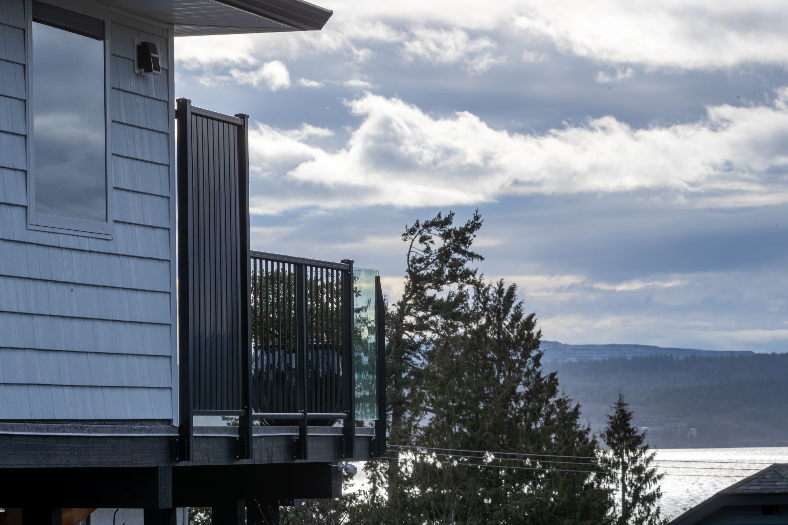 Aluminum picket and glass railing on elevated deck showing non-combustible materials on exposed perimeter